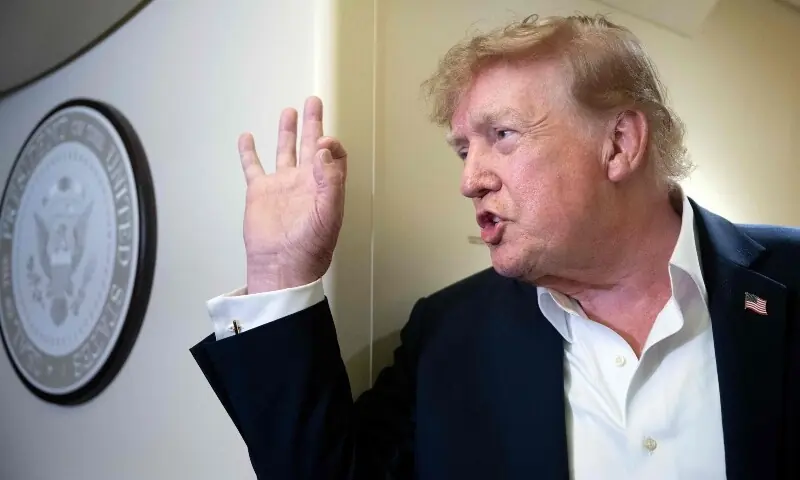 US President Donald Trump gestures while speaking to reporters aboard Air Force One during a flight.